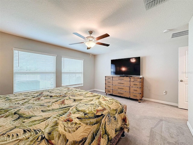 carpeted bedroom featuring a textured ceiling and ceiling fan