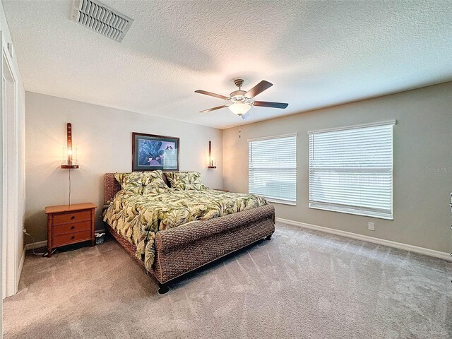 carpeted bedroom with a textured ceiling and ceiling fan