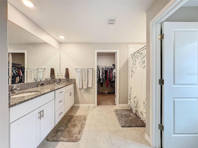 bathroom featuring walk in shower, tile patterned flooring, vanity, and a textured ceiling