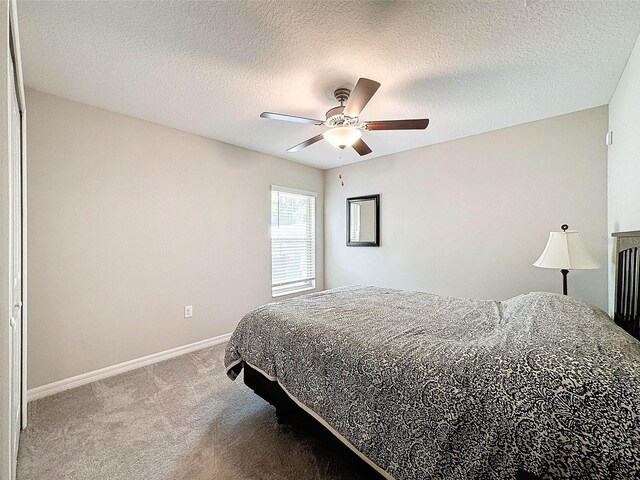 bedroom featuring carpet, a textured ceiling, and ceiling fan