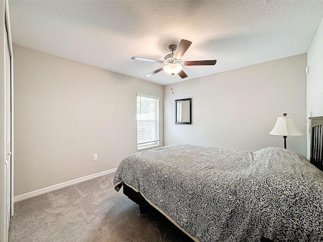 carpeted bedroom featuring ceiling fan and a textured ceiling