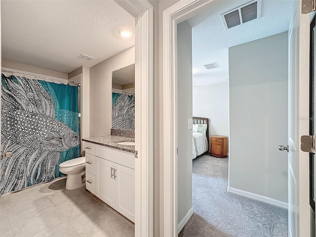 bathroom featuring vanity, toilet, and a textured ceiling