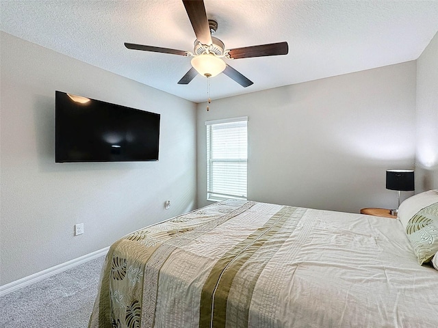 carpeted bedroom featuring a textured ceiling and ceiling fan