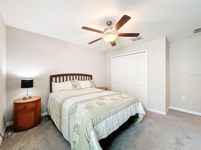 bedroom featuring a closet, a textured ceiling, light carpet, and ceiling fan