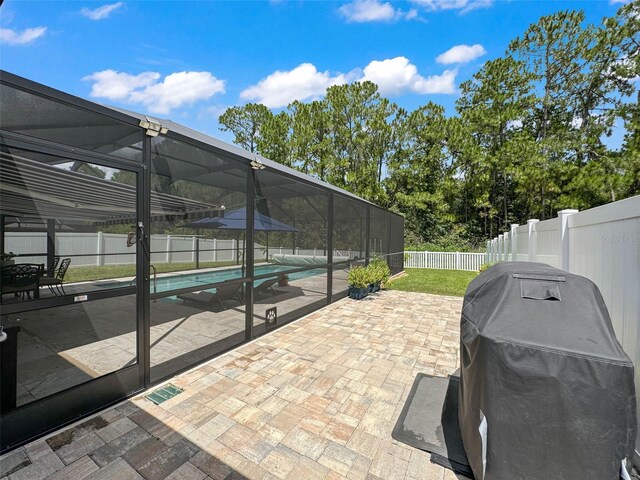 view of patio with a grill, glass enclosure, and a fenced in pool