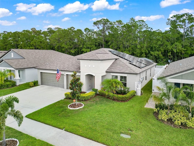 view of front of house featuring a garage, a front lawn, and solar panels