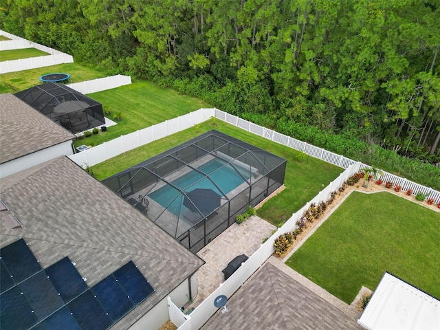 view of pool with a lanai and a lawn