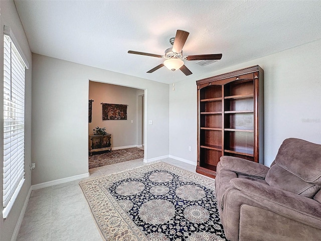 living room with a textured ceiling and ceiling fan