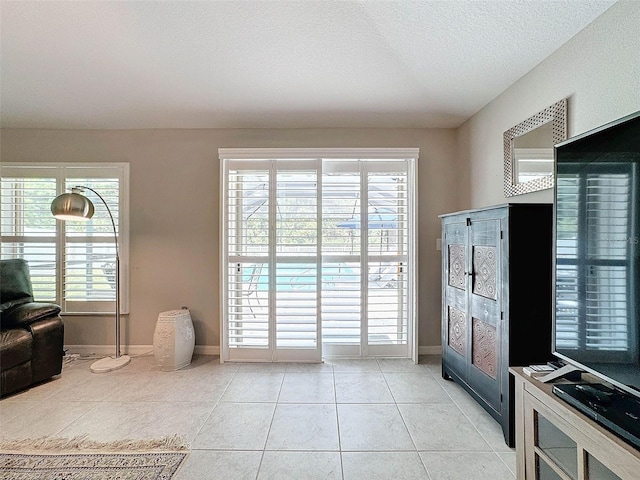 entryway with light tile patterned flooring and a textured ceiling