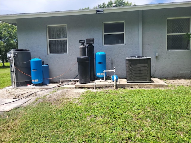 back of house featuring central AC and a lawn