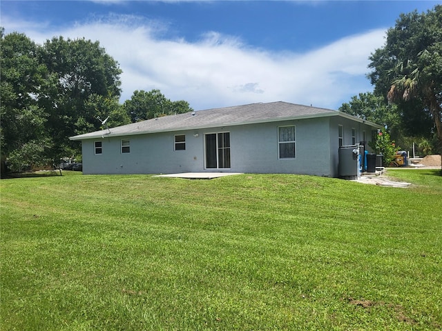 rear view of house with a lawn and a patio