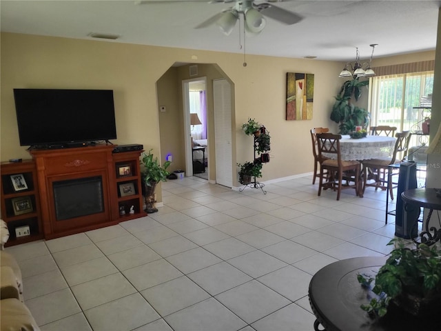 living room featuring ceiling fan with notable chandelier and light tile patterned floors