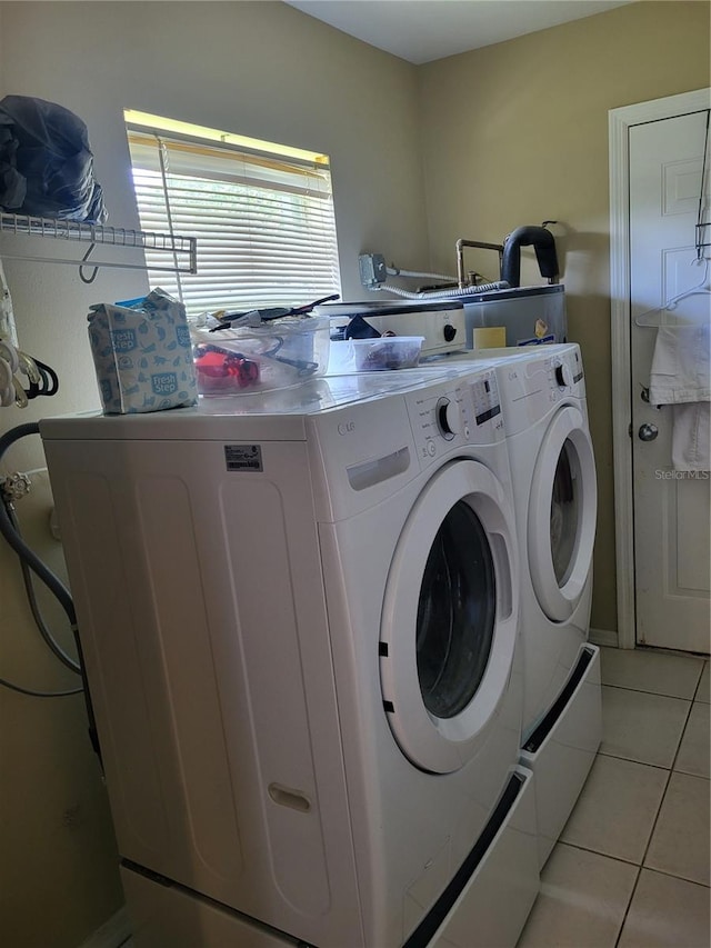 laundry area with separate washer and dryer and light tile patterned flooring