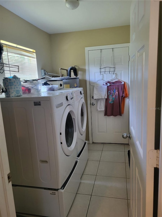 laundry room featuring washing machine and dryer and light tile patterned floors