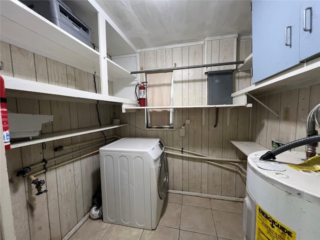 clothes washing area featuring washer / clothes dryer, wooden walls, water heater, light tile patterned floors, and electric panel