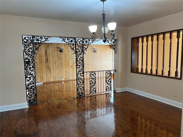 unfurnished dining area with an inviting chandelier and dark hardwood / wood-style floors