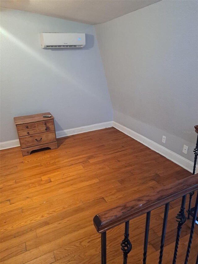 interior space featuring a wall mounted air conditioner and hardwood / wood-style flooring