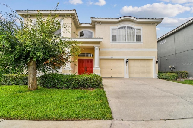 mediterranean / spanish home with an attached garage, driveway, a tiled roof, stucco siding, and a front lawn