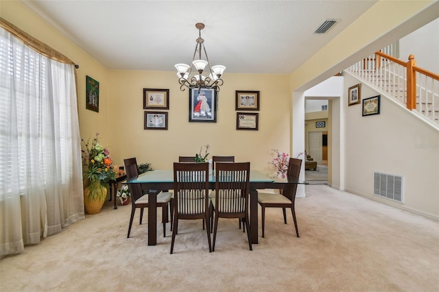 dining area featuring an inviting chandelier, stairway, visible vents, and light colored carpet