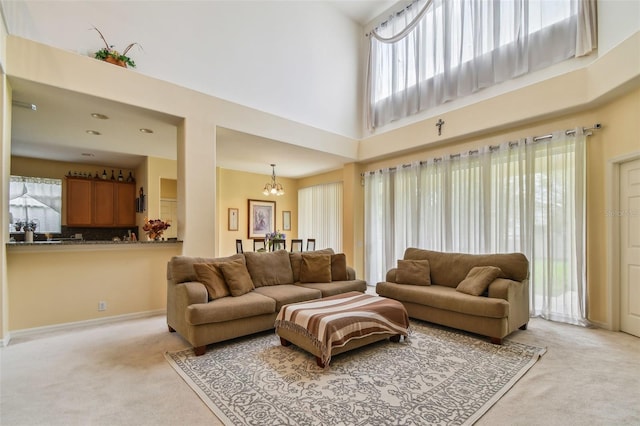 living area with carpet, a high ceiling, and a chandelier