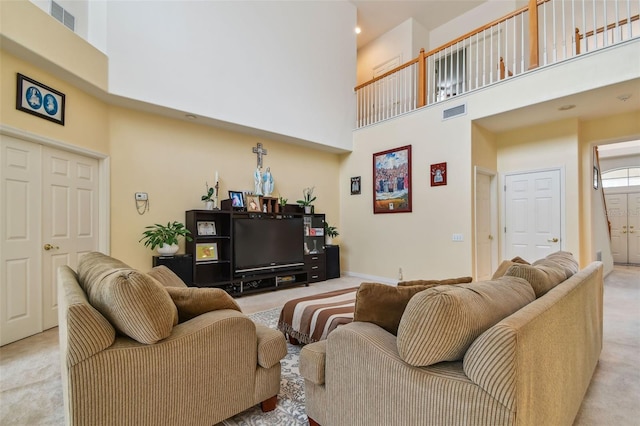 living room with light carpet, baseboards, a high ceiling, and visible vents