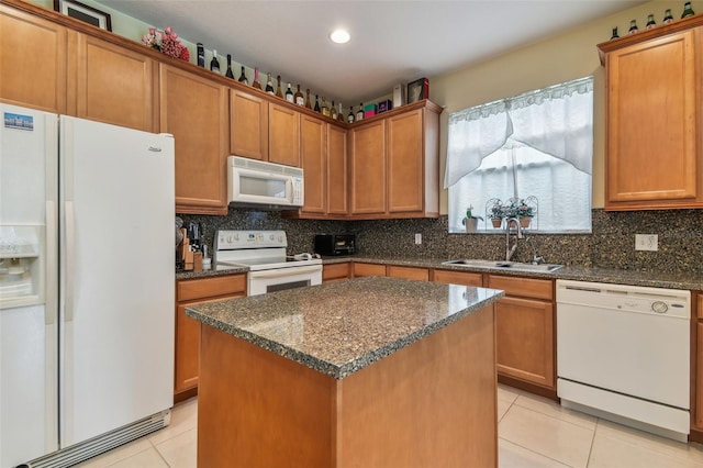 kitchen with light tile patterned floors, tasteful backsplash, a sink, dark stone counters, and white appliances