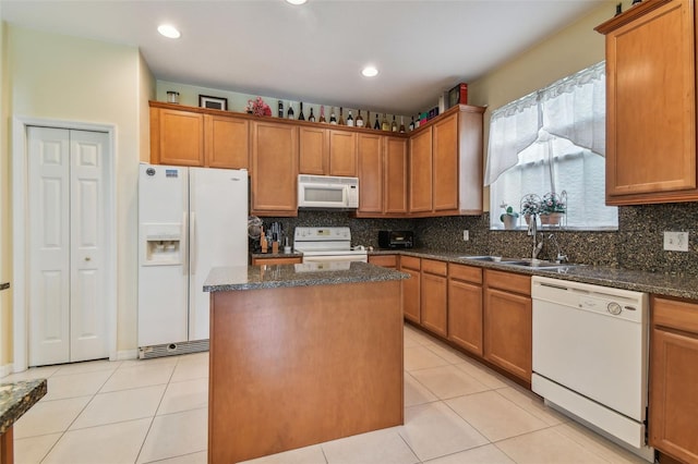 kitchen featuring white appliances, a kitchen island, a sink, backsplash, and light tile patterned flooring