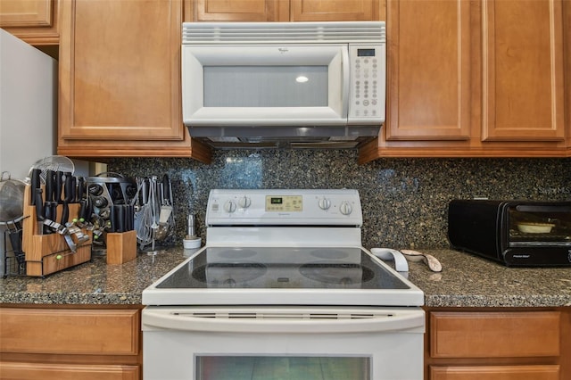 kitchen with brown cabinets, a toaster, dark countertops, decorative backsplash, and white appliances