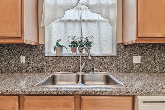 interior details featuring dark countertops, decorative backsplash, and a sink