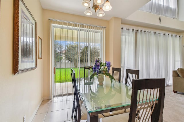 dining area with a chandelier, light tile patterned flooring, and baseboards