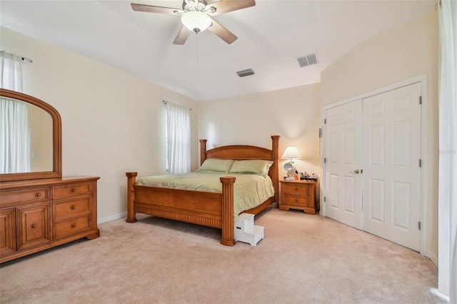 bedroom featuring light carpet, a closet, visible vents, and a ceiling fan