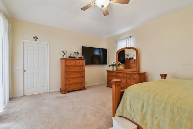 bedroom featuring a ceiling fan, light carpet, and baseboards