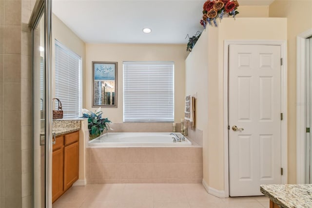 full bathroom with a garden tub, vanity, a tile shower, and tile patterned floors