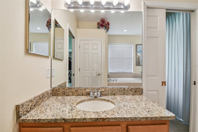 bathroom with vanity and a bath