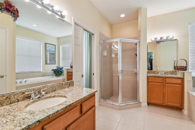 full bath with a stall shower, a sink, a garden tub, tile patterned flooring, and two vanities