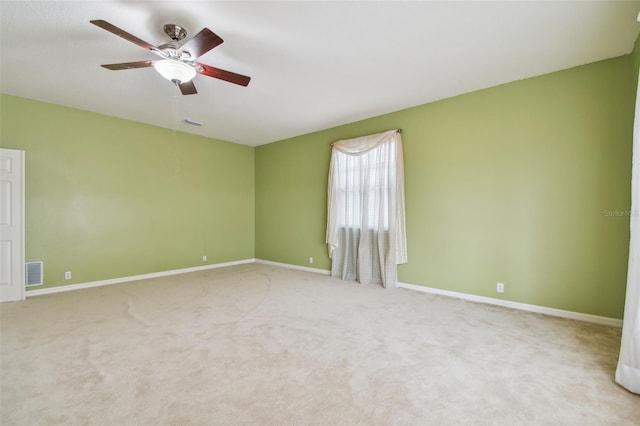 spare room featuring carpet floors, baseboards, visible vents, and a ceiling fan