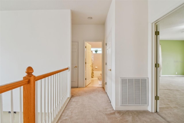 hall featuring carpet flooring and visible vents