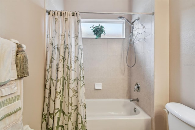 bathroom featuring shower / bath combo and toilet