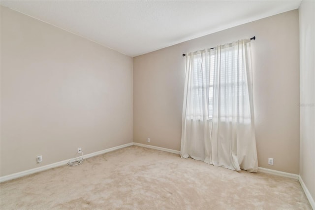 unfurnished room with carpet floors and baseboards