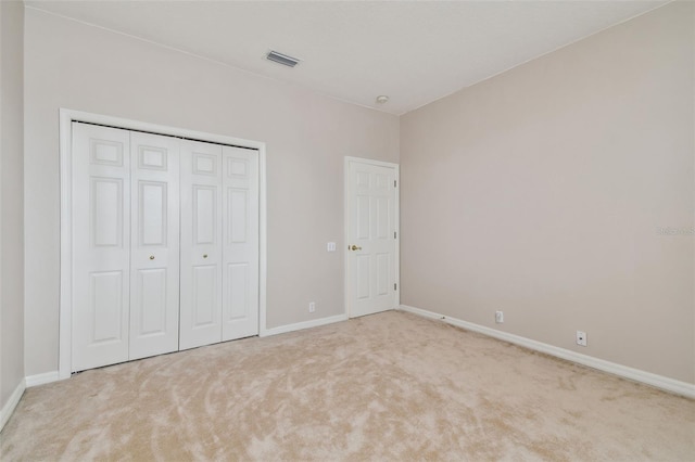 unfurnished bedroom with carpet floors, visible vents, and baseboards