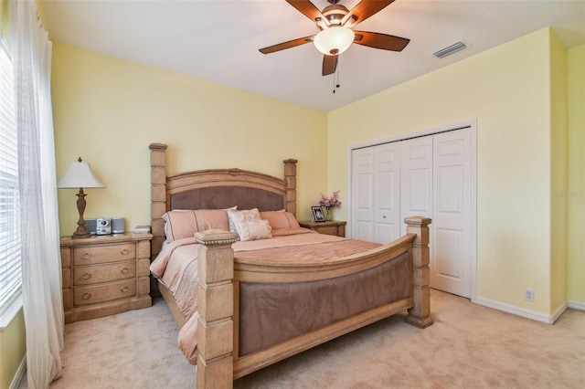 bedroom featuring baseboards, visible vents, a closet, and light colored carpet