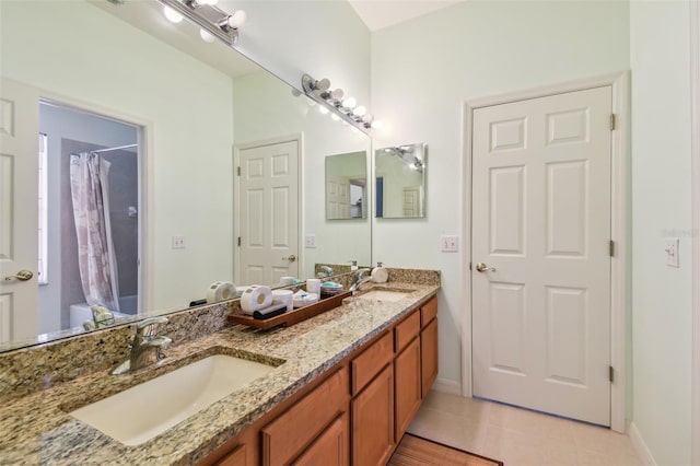 bathroom with curtained shower, a sink, baseboards, and double vanity