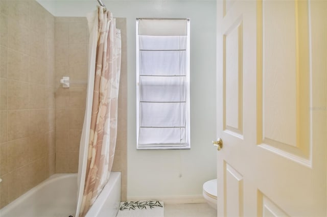 bathroom featuring baseboards, toilet, and shower / bath combo with shower curtain