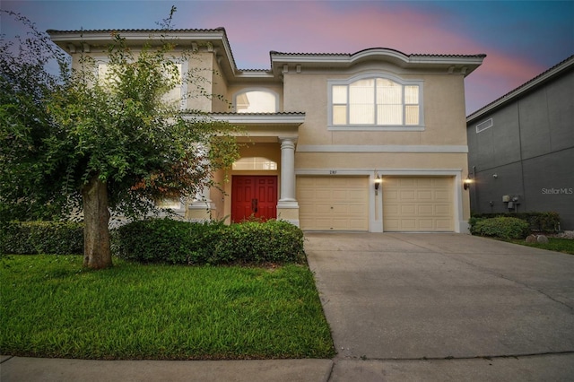 mediterranean / spanish home featuring a garage, concrete driveway, a tiled roof, and stucco siding