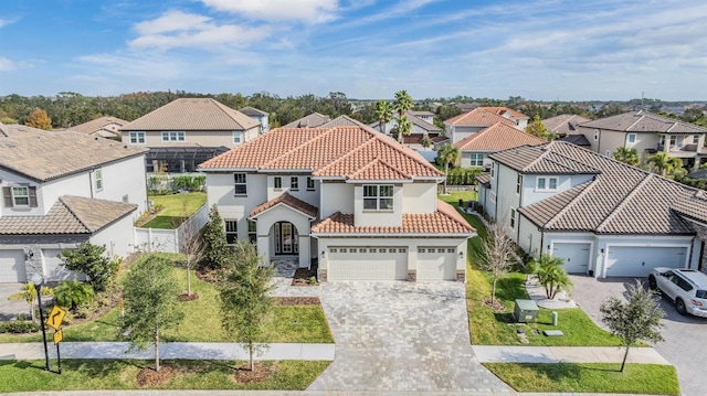 mediterranean / spanish-style home featuring a garage and a front lawn