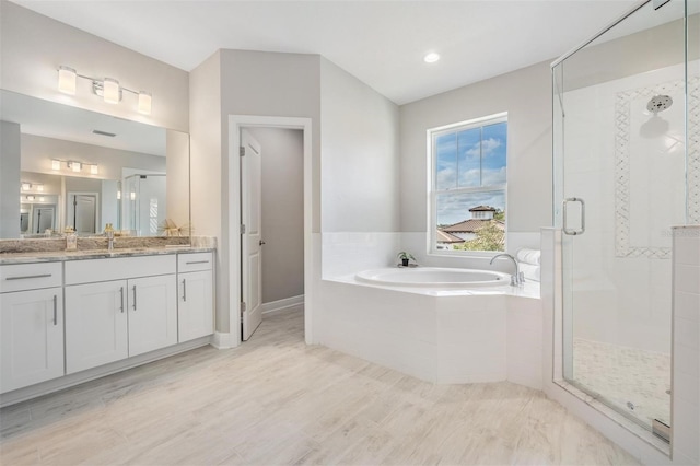 bathroom featuring hardwood / wood-style floors, vanity, and independent shower and bath