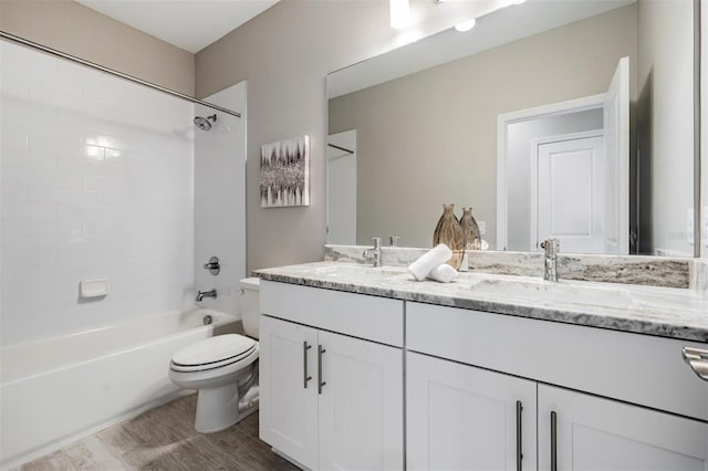 full bathroom with hardwood / wood-style flooring, tiled shower / bath combo, toilet, and vanity