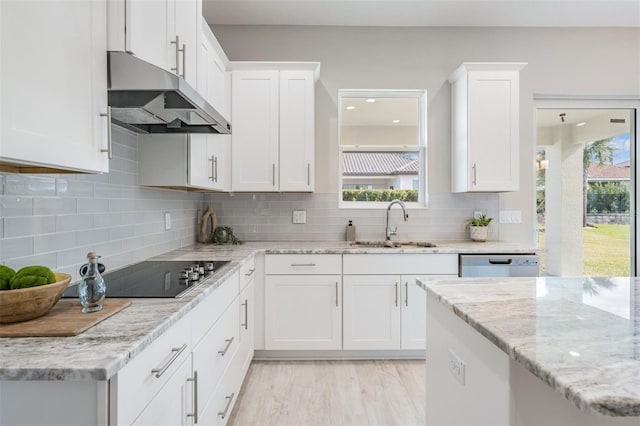 kitchen with black electric cooktop, white cabinetry, a wealth of natural light, and sink