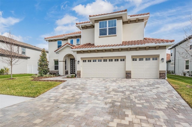 mediterranean / spanish-style home with a garage and a front lawn