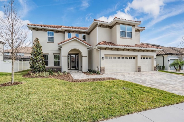 mediterranean / spanish home featuring a front lawn and a garage